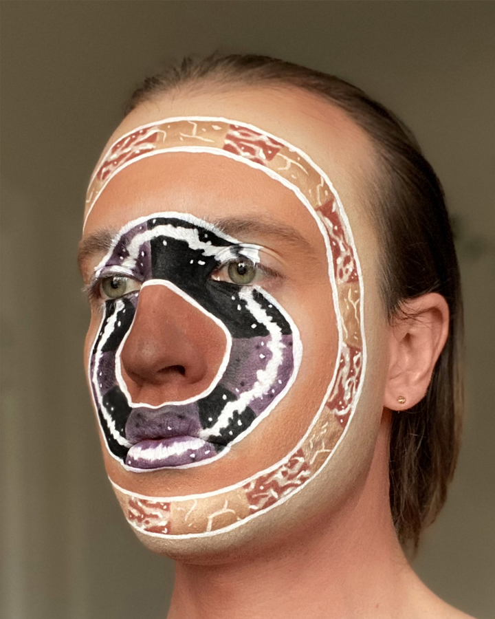 Jesse with intricate graphic facepaint mimicing Isamu Noguchi marble round sculptures